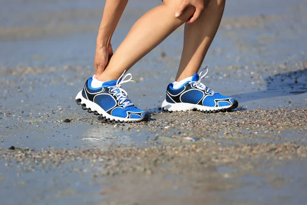 Žena běžec s kroucenými kotník — Stock fotografie