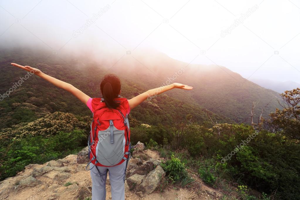 Cheering woman at mountain peak