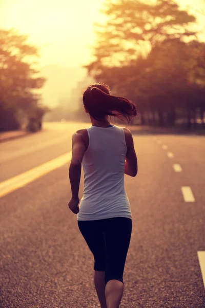 Atleta feminina correndo na estrada — Fotografia de Stock