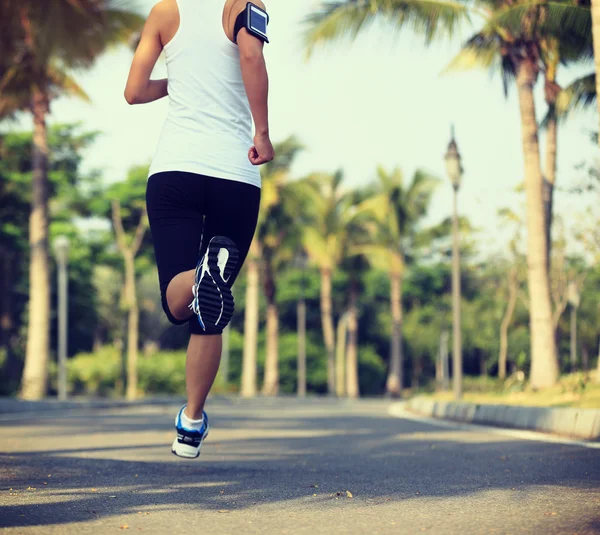 Vrouwelijke jogger benen draait op park. — Stockfoto