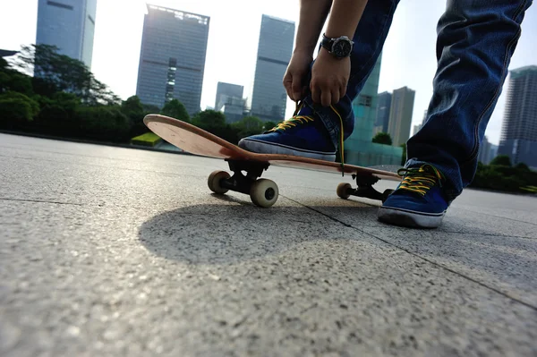 Skateboardista vázání tkaničky — Stock fotografie