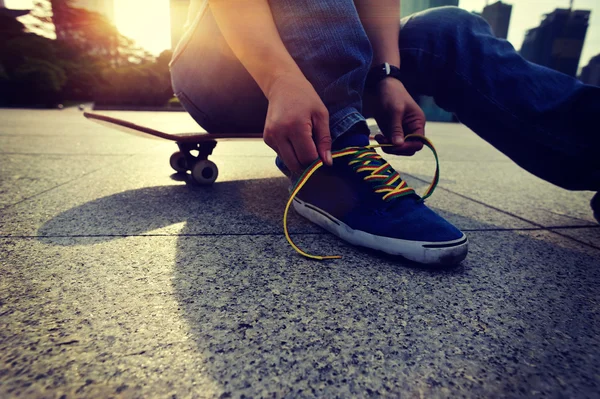 Skateboarder tying shoelace — Stock Photo, Image