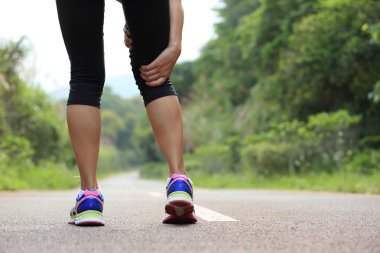 Genç fitness kadın jogger orman iz spor yaralı bacak tutun