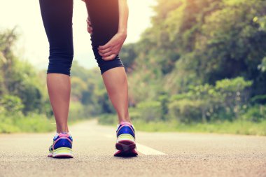 Kadın jogger spor yaralı bacak tutun