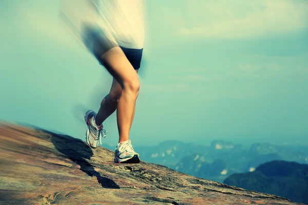 Mujer joven corriendo en la montaña — Foto de Stock