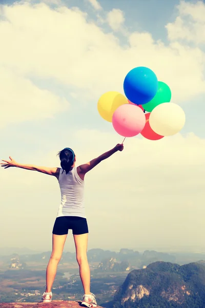 Donna sulla vetta della montagna con palloncini — Foto Stock