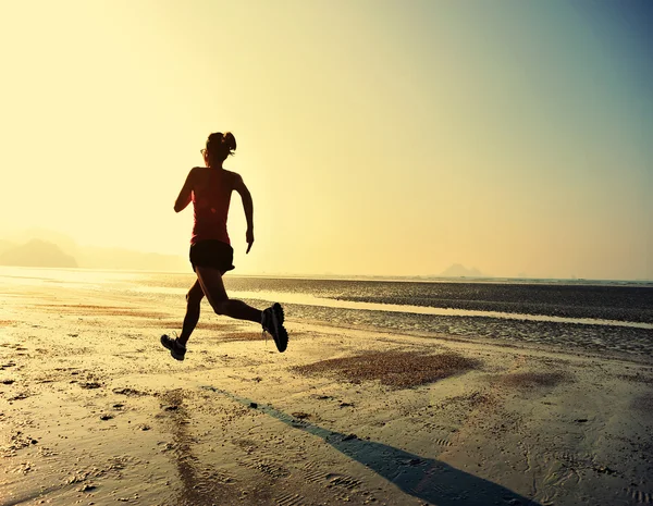 Woman running at sunrise beach — Stock Photo, Image
