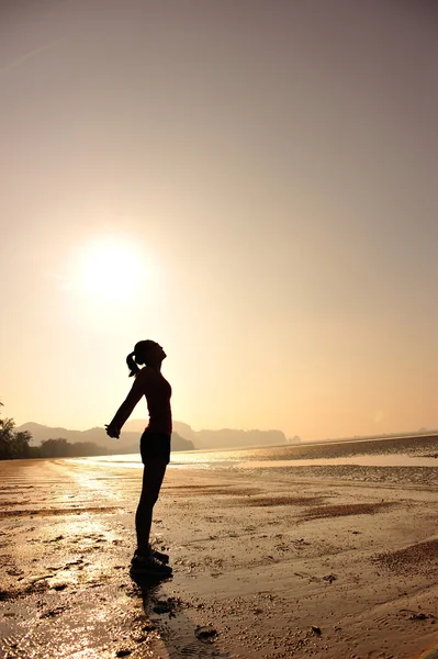 Mulher se alongando na praia — Fotografia de Stock