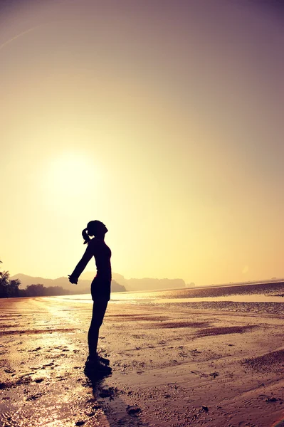 Kvinnan sträcker sig på stranden — Stockfoto