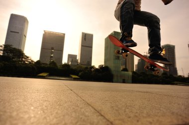 Skateboarder skateboarding over city clipart