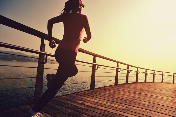 woman running on wooden boardwalk