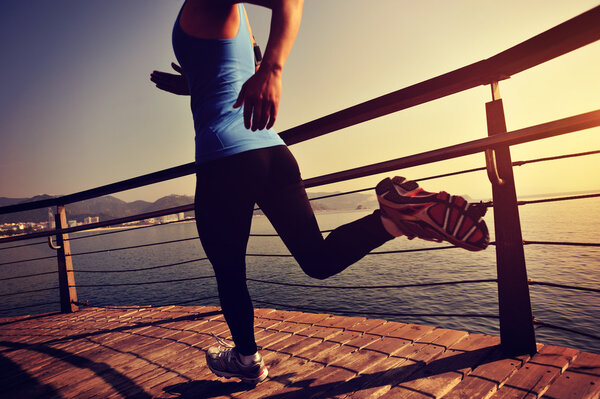 woman running on wooden boardwalk