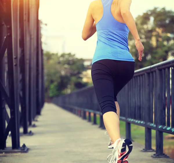 Sportovec běžec běží na železném mostě. — Stock fotografie
