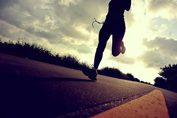 Löpare idrottsman kör på seaside road — Stockfoto