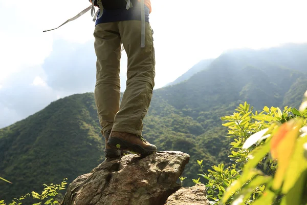 在山顶岩石上攀爬的女子徒步者 — 图库照片
