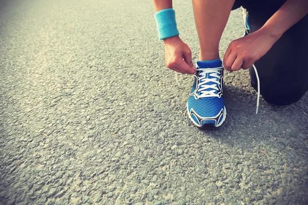 Young woman tying shoelaces — Stock Photo, Image