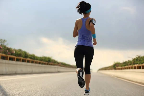 Female athlete running on road — Stock Photo, Image