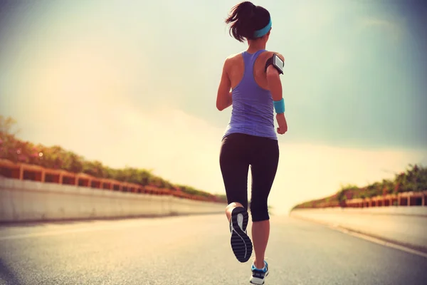 Female athlete running on road — Stock Photo, Image