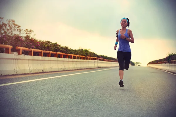 Female athlete running on road — Stock Photo, Image