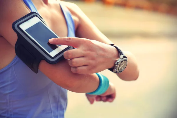 Runner escuchando música desde un teléfono inteligente — Foto de Stock