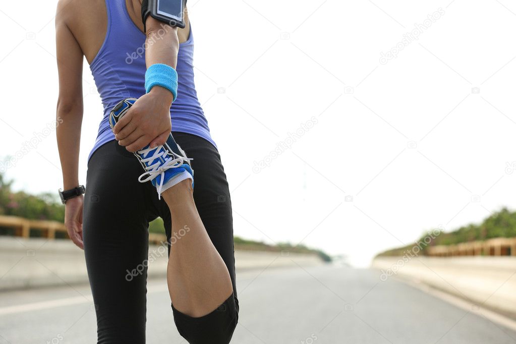 young woman runner warming up outdoor