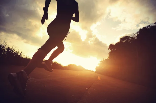 Atleta feminino correndo na estrada à beira-mar — Fotografia de Stock