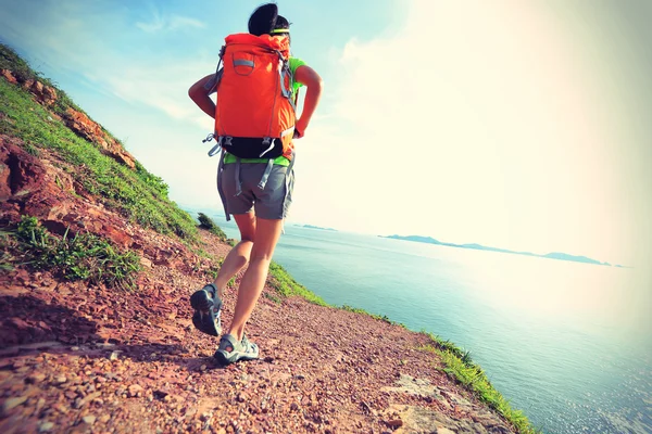 Backpackerin spaziert am Meer — Stockfoto