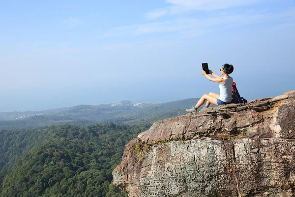 Женщина фотографируется с цифровым планшетом — стоковое фото