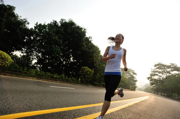 Female athlete running at road — Stock Photo, Image