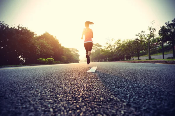 Vrouwelijke atleet draait op weg — Stockfoto