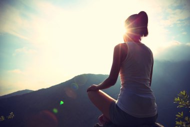 yoga woman meditating on mountain