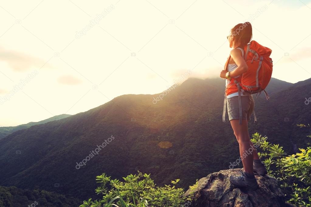 woman backpacker on mountain peak