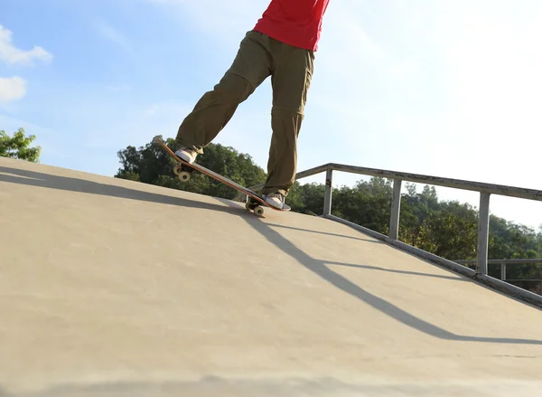 Skateboardista nohy dělá trik ollie — Stock fotografie