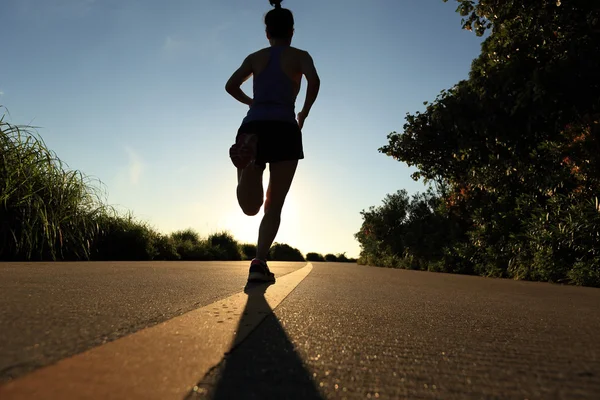 Jeune femme de fitness courant au lever du soleil — Photo