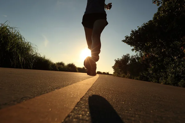 Jovem mulher fitness correndo ao nascer do sol — Fotografia de Stock