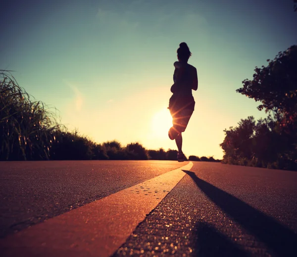 Fitness-Frau läuft bei Sonnenaufgang — Stockfoto