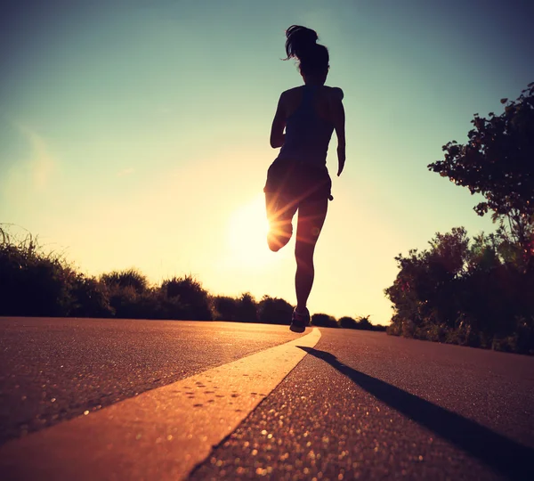 Фитнес-женщина бежит на восходе солнца — стоковое фото