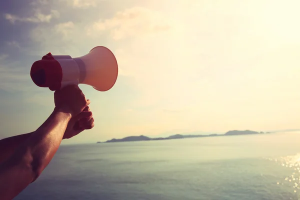 Hand hold megaphone  under sunrise — Stock Photo, Image