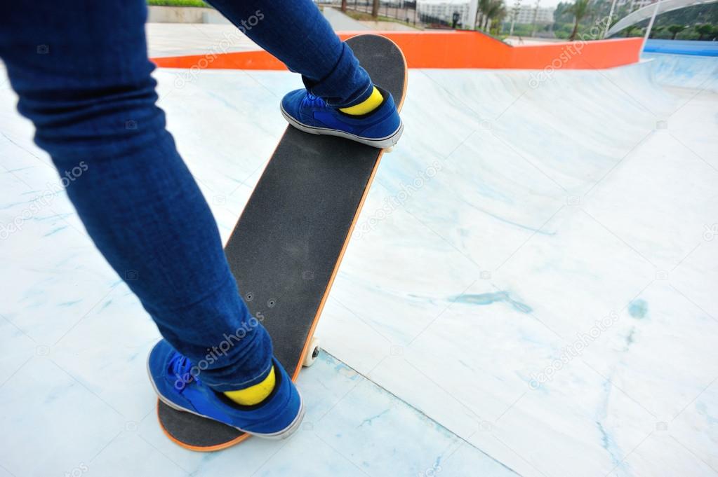 Skateboarder legs riding skateboard