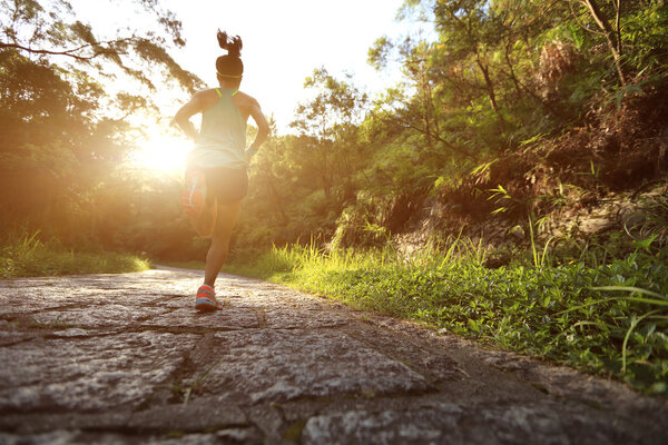 Runner athlete running on forest trail