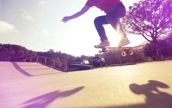 Skateboarder pernas fazendo truque ollie — Fotografia de Stock