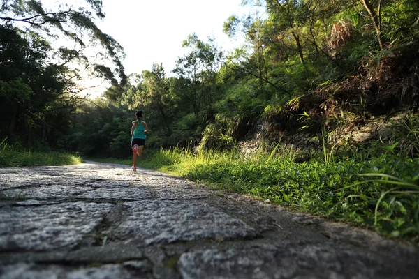 Runner athlete running on forest trail.