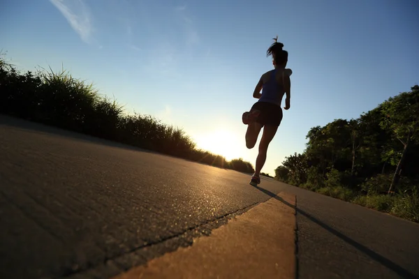 Jovem mulher fitness correndo ao nascer do sol — Fotografia de Stock