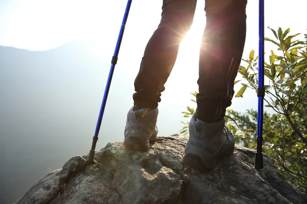 Joven mujer excursionista piernas en la montaña — Foto de Stock