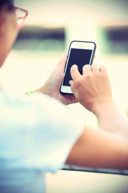 Şehirde akıllı telefon kullanan kadın.