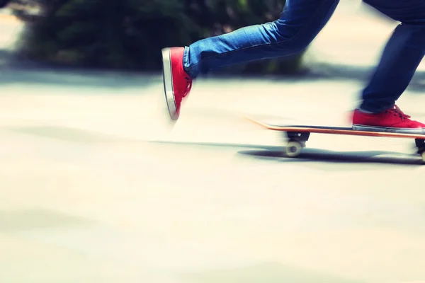 Jonge skateboarder benen op skateboard — Stockfoto