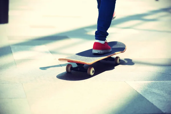 Jonge skateboarder benen op skateboard — Stockfoto
