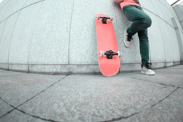 Unga kvinnliga skateboard med hjälp av mobiltelefon — Stockfoto