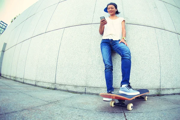 Joven monopatín femenino usando el teléfono celular — Foto de Stock