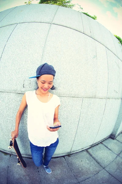 Jonge skateboard met behulp van mobiele telefoon — Stockfoto